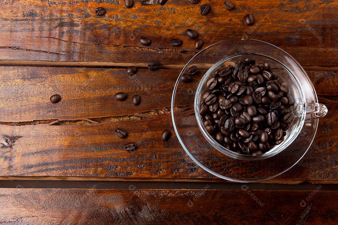 xícara de café isolada com grãos torrados e frescos na mesa de madeira rústica. Vista de cima e de perto