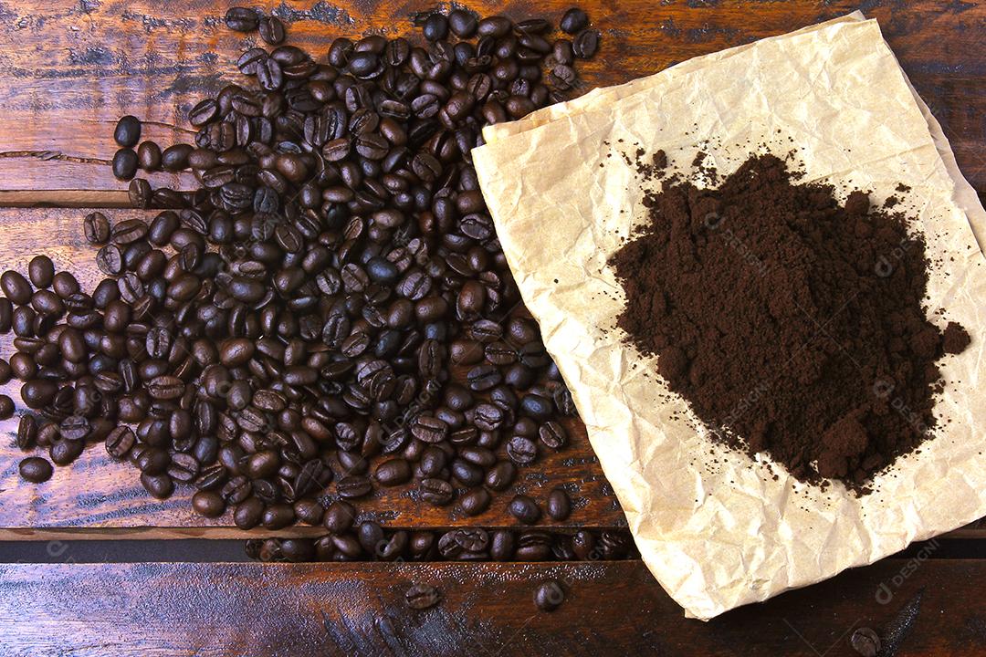 grãos de café torrados e café moído em papel sobre mesa rústica. Vista do topo