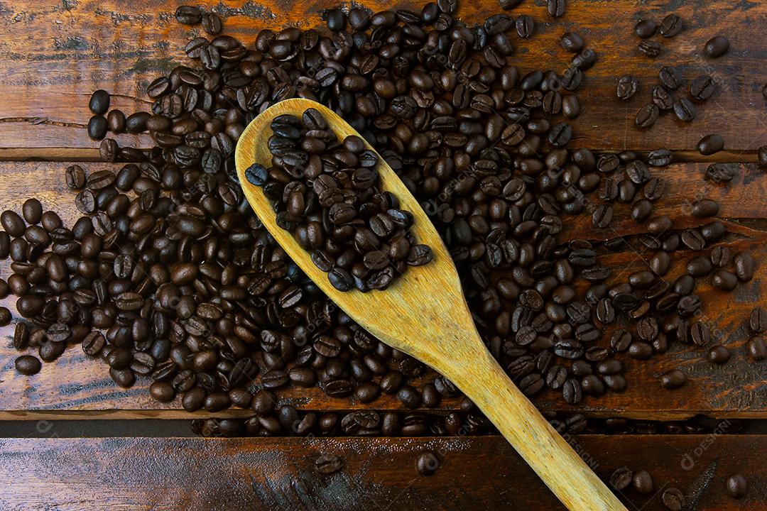 grãos de café torrados e flash espalhados sobre a mesa de madeira rústica. Vista do topo