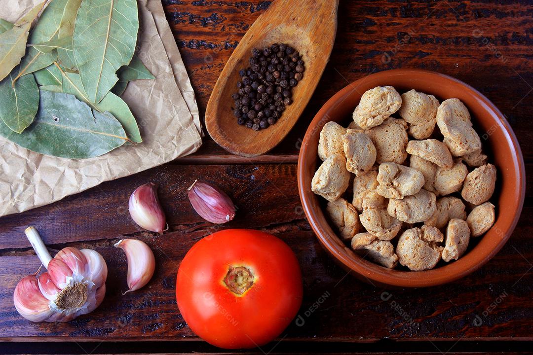 Carne de soja, pedaços em uma panela rústica. Vista superior de pedaços de soja crua em fundo de madeira rústica