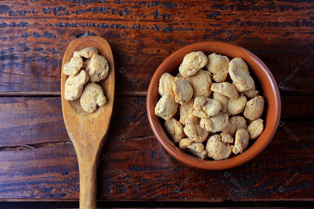 Soy meat pieces in a rustic pan. Top view of raw soybean chunks on rustic wooden background