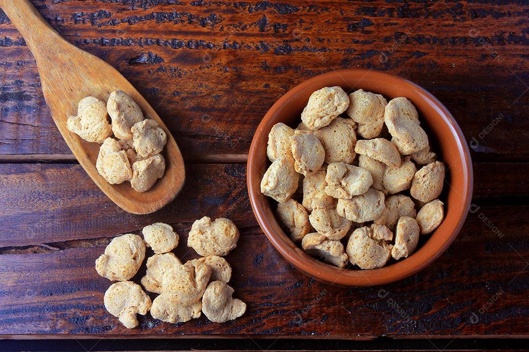 Carne de soja, pedaços em uma panela rústica. Vista superior de pedaços de soja crua em fundo de madeira rústica