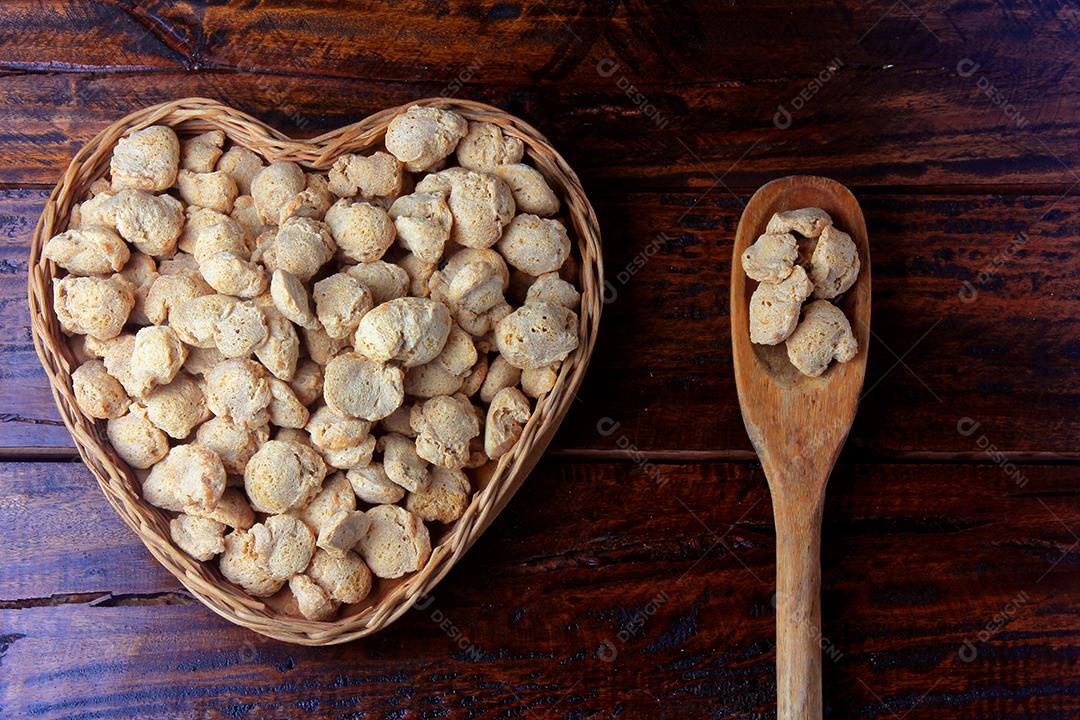 Carne de soja, pedaços em uma cesta com forma de coração. Vista superior de pedaços de soja crua em fundo de madeira rústica