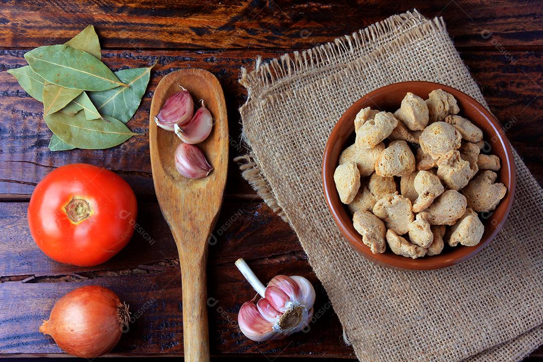 Carne de soja, pedaços em uma tigela de cerâmica marrom. Vista superior de pedaços de soja crua