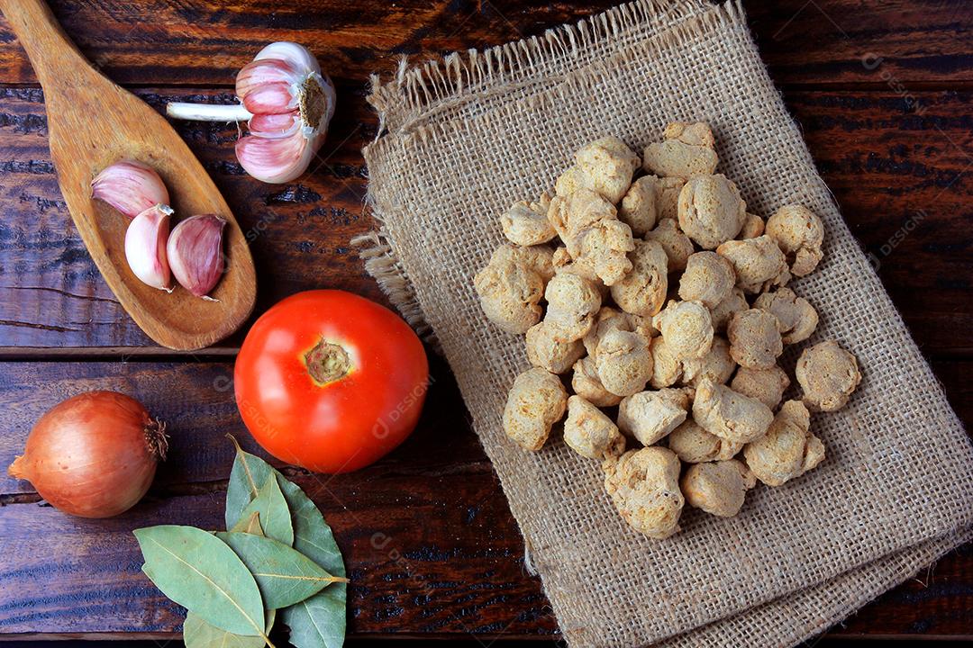 Carne de soja, pedaços em uma tigela de cerâmica marrom. Vista superior de pedaços de soja crua