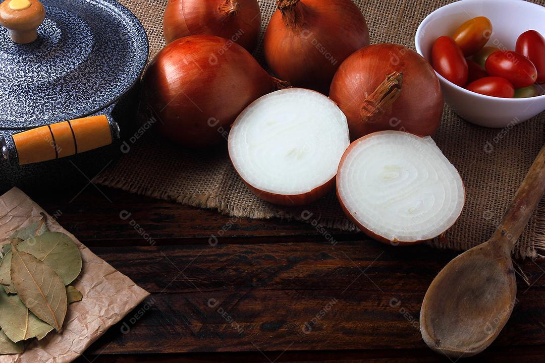 ingredientes da sopa de cebola e panela e colher mesa de cozinha de madeira rústica. Vista aproximada