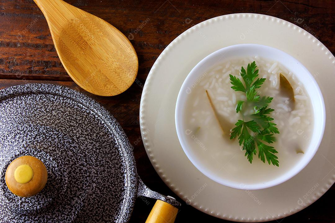 mingau em tigela de cerâmica na mesa de madeira rústica, mingau de arroz tradicional típico da cozinha asiática. Vista do topo
