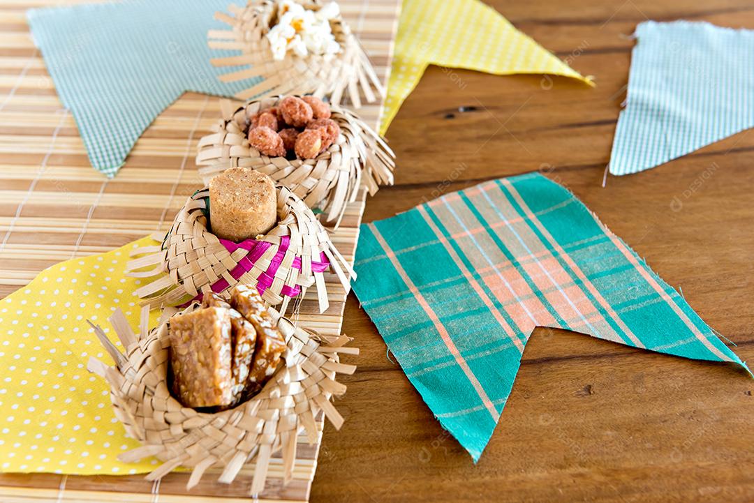 Mesa decorada Festa Junina brasileira, chapéu de palha, banners e doces