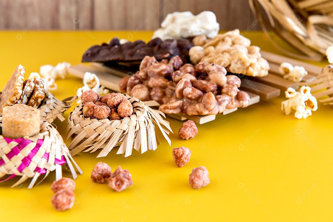 Festa Junina brasileira decorada mesa amarela, chapéu de palha e doces