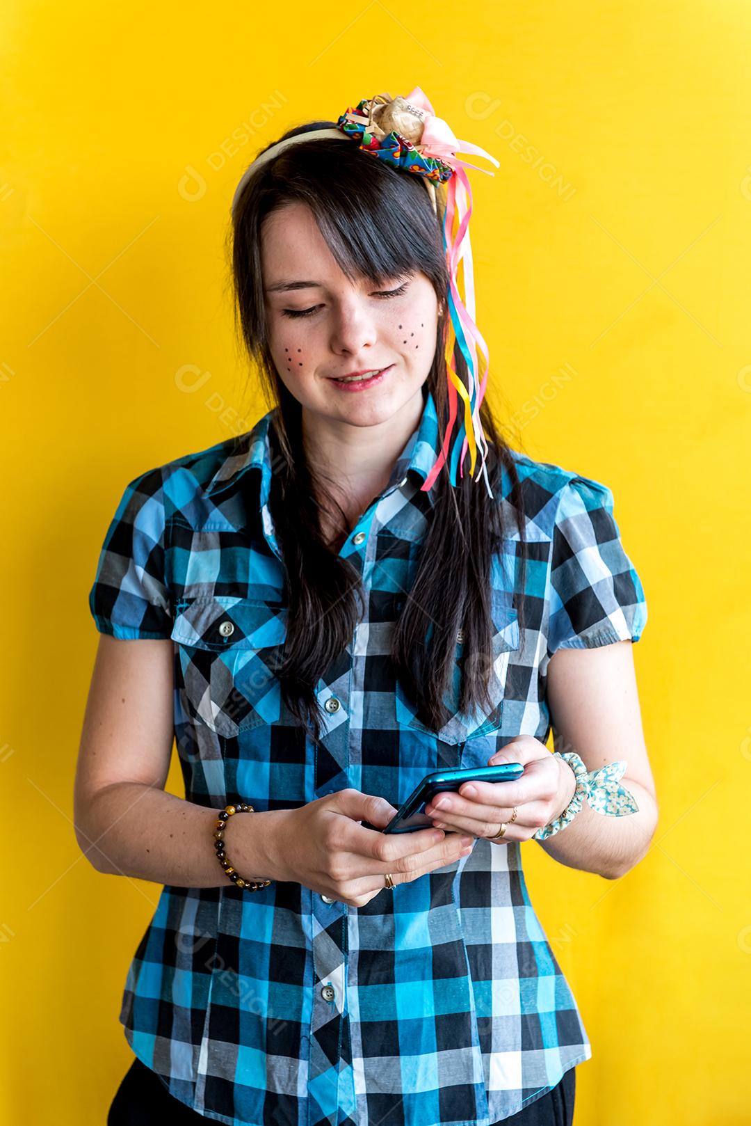 Garota brasileira em festa junina segurando um celular