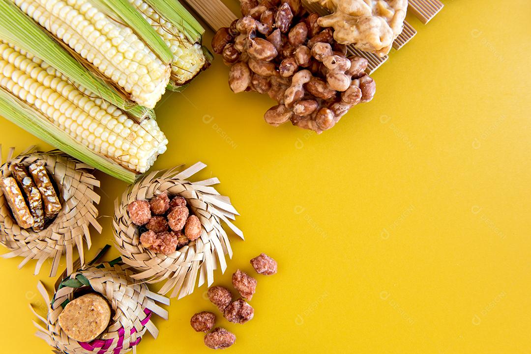 Doces da festa junina brasileira, chapéu de palha, milho, paçoca e amendoim doce