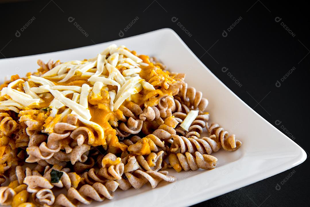 Macarrão Fusilli com molho de abóbora e queijo colonial em fundo preto