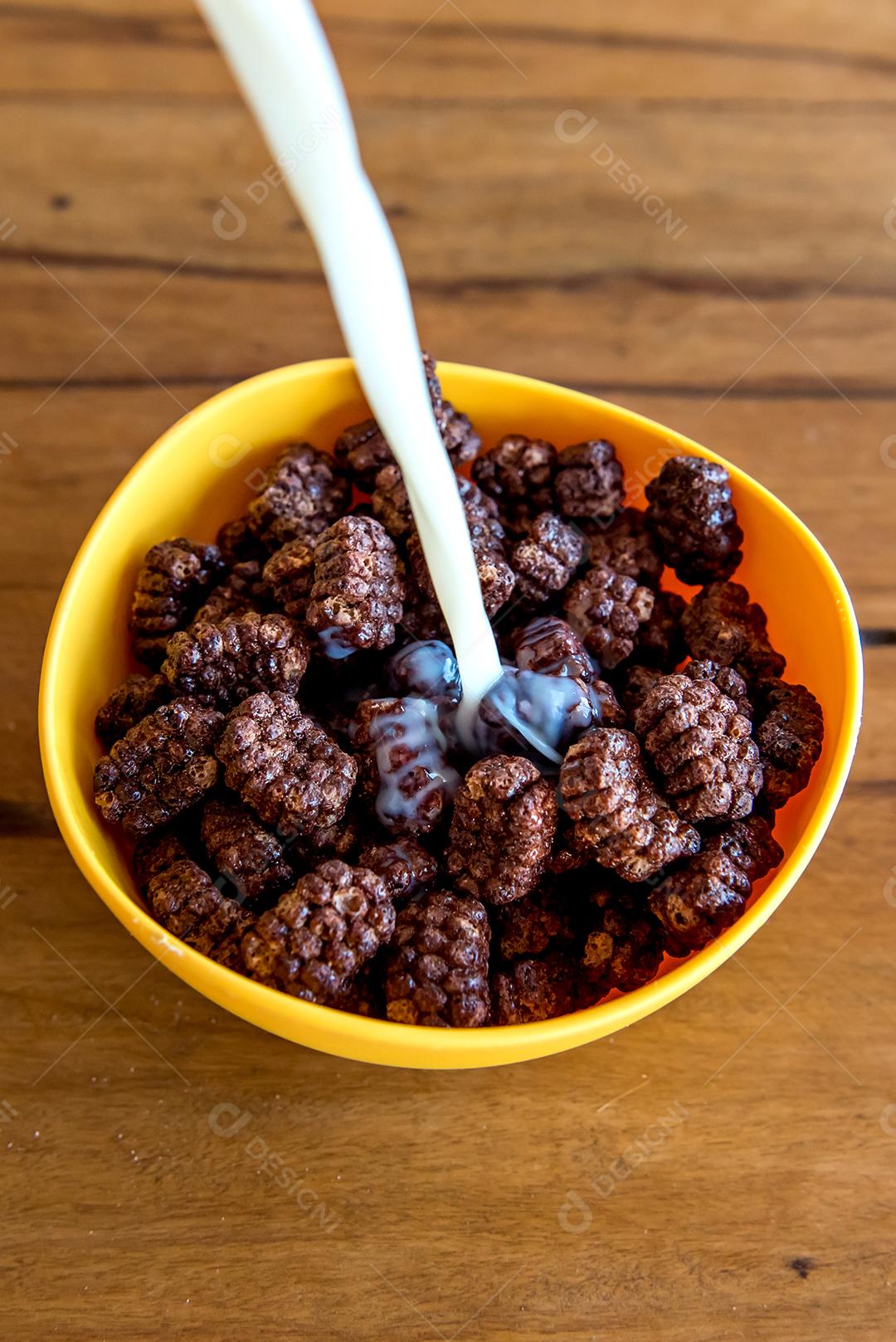 Derramando leite em bolas de chocolate com flocos de milho Café da manhã com leite e flocos de milho