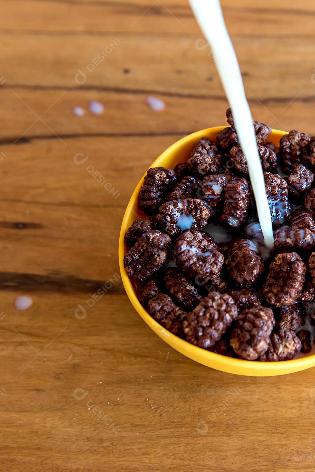 Derramando leite em bolas de chocolate com flocos de milho Café da manhã com leite e flocos de milho