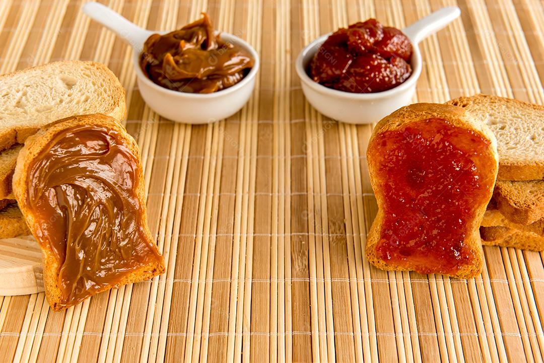 Pão torrado com geléia e doce de leite em uma mesa de café da manhã