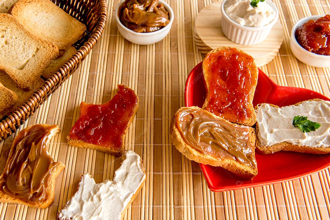 Pão torrado com geléia, doce de leite e creme de ricota em uma mesa de café da manhã