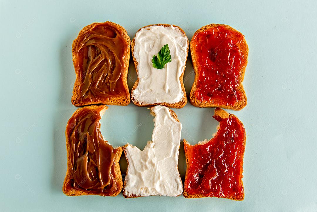 Pão torrado com geléia, doce de leite e creme de ricota em fundo azul
