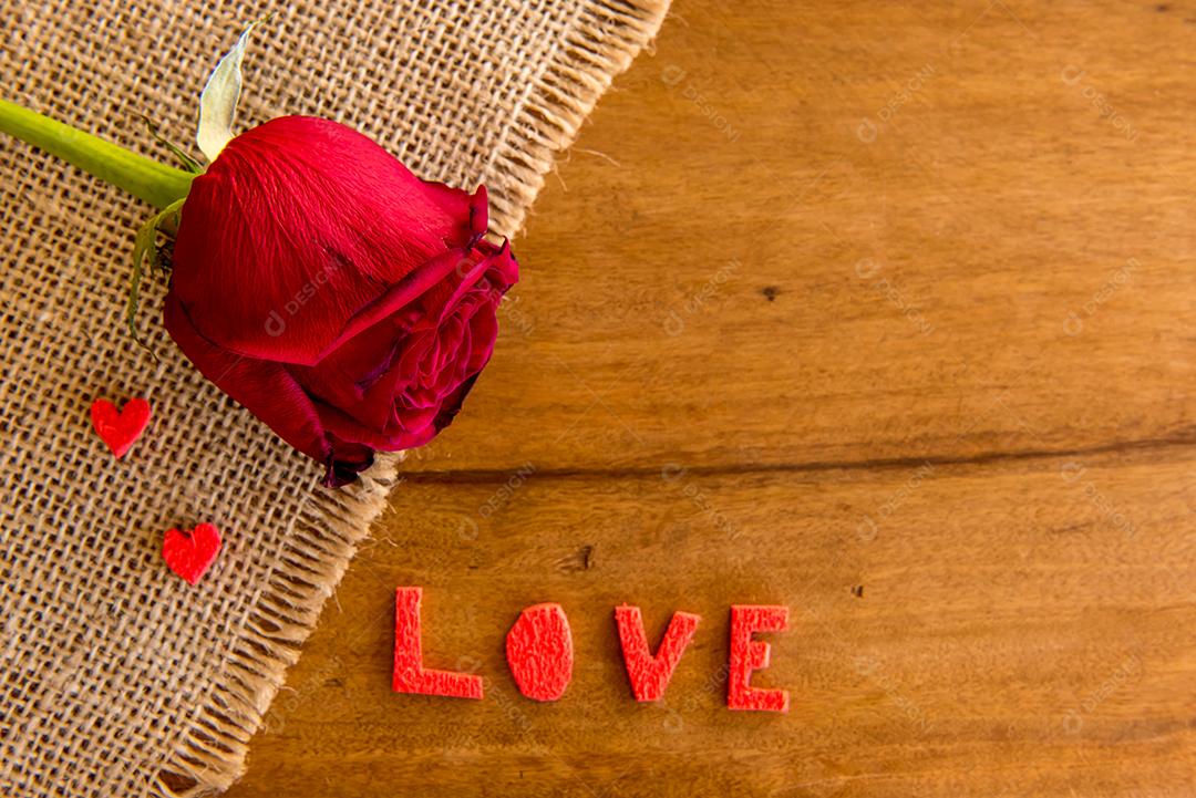 Conceito de dia dos namorados, amor, corações e rosa na mesa de madeira