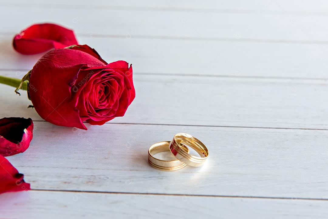 Conceito de dia dos namorados, anéis de casamento rosa e ouro na mesa de madeira