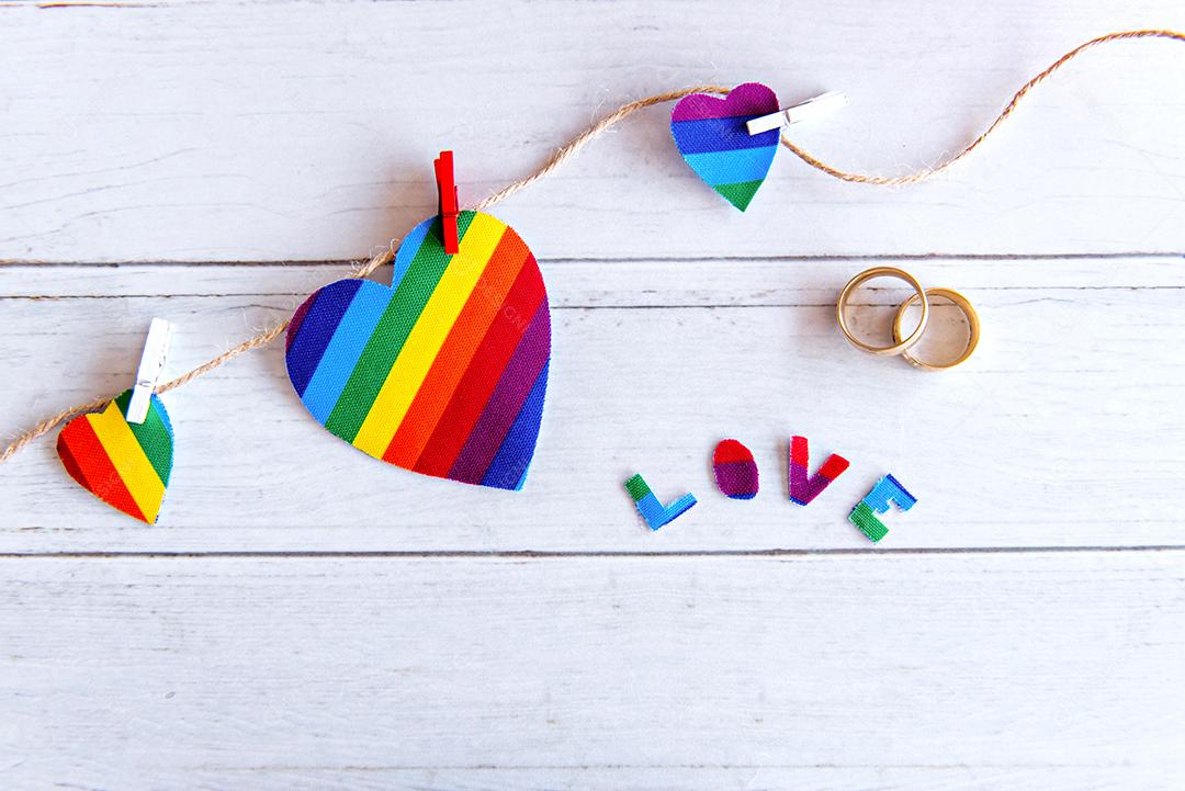 Conceito de dia dos namorados LGBT, corações coloridos e anéis de casamento