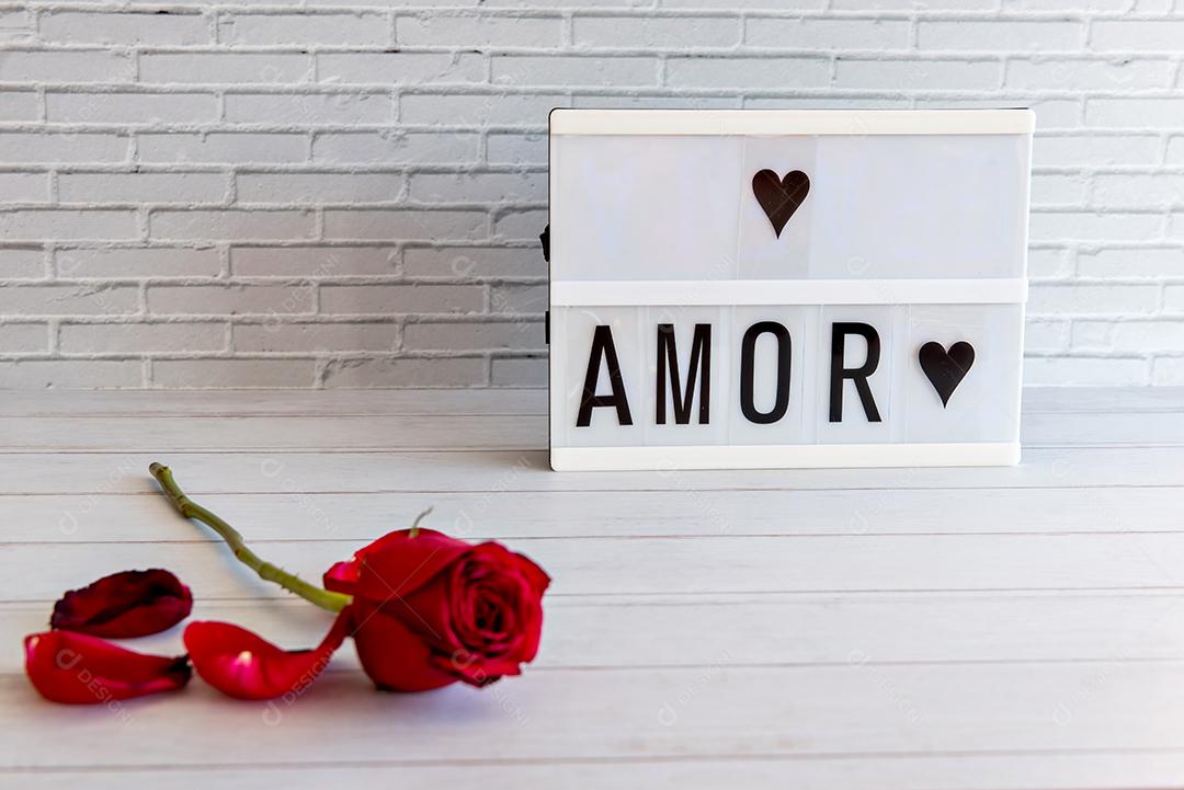 Conceito de dia dos namorados, rosas e sinal com amor escrito em português (amor)