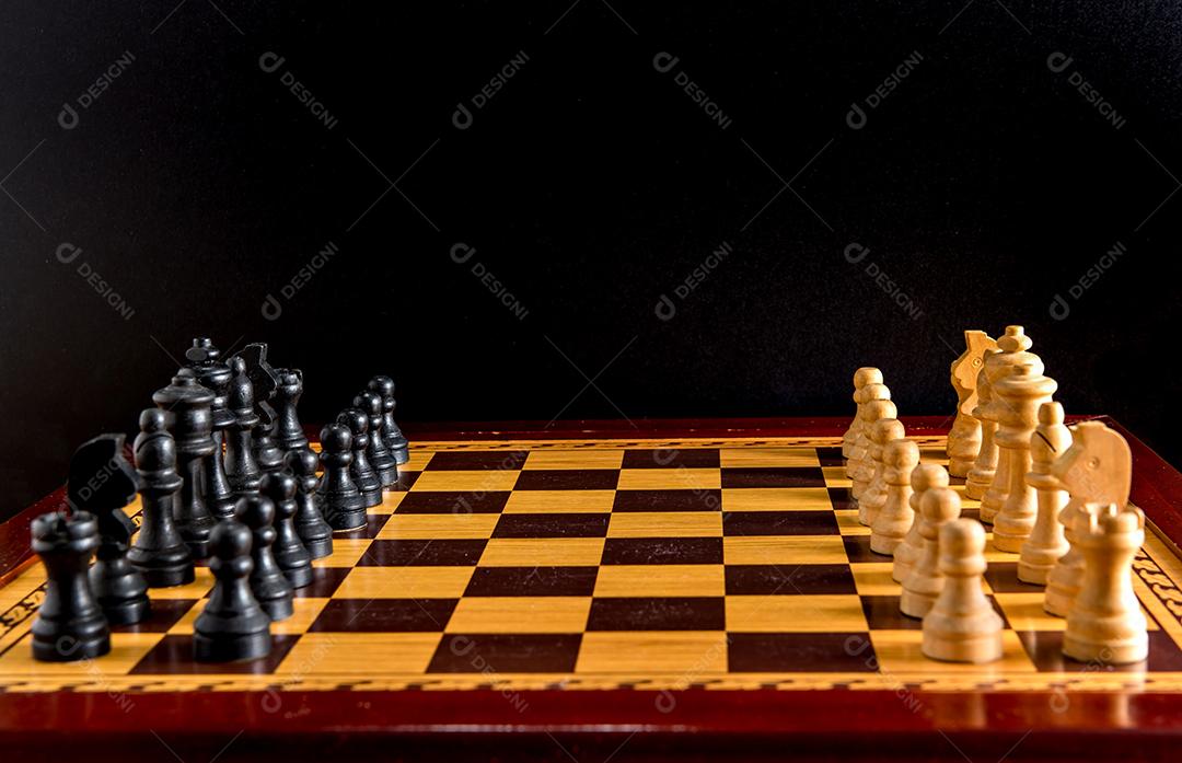 Batalha de xadrez em um tabuleiro de madeira, jogo de xadrez em um fundo preto