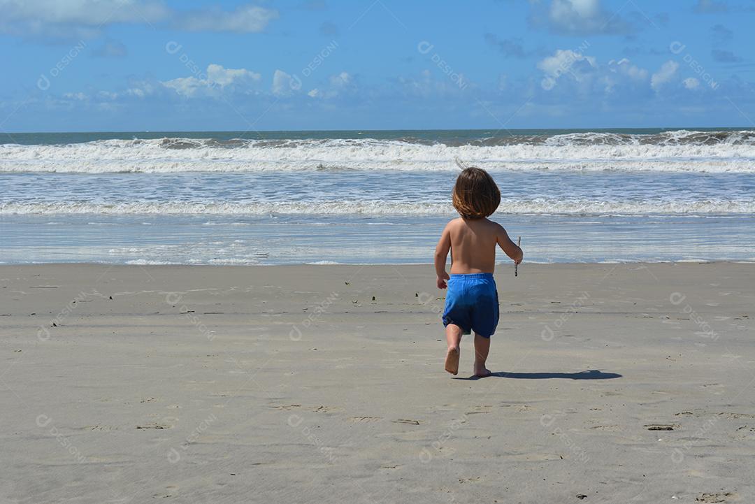 Menino correndo na praia