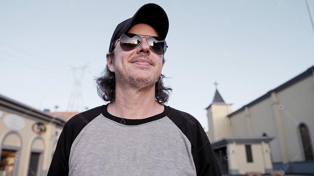 Elegante modelo latino com longos cabelos ruivos e estilo de vida de barba na cidade ao pôr do sol.