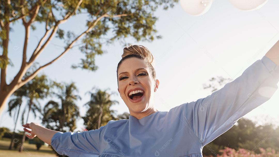 Feliz linda mulher latina andando e dançando no parque. Jovem loira aproveita o dia.
