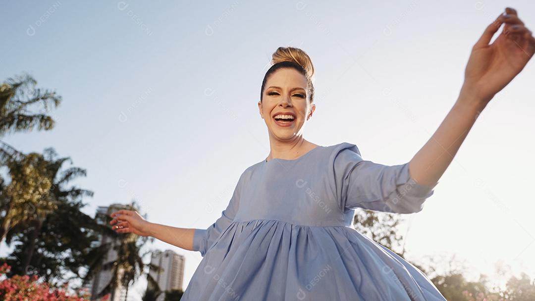 Feliz linda mulher latina andando e dançando no parque. Jovem loira aproveita o dia.