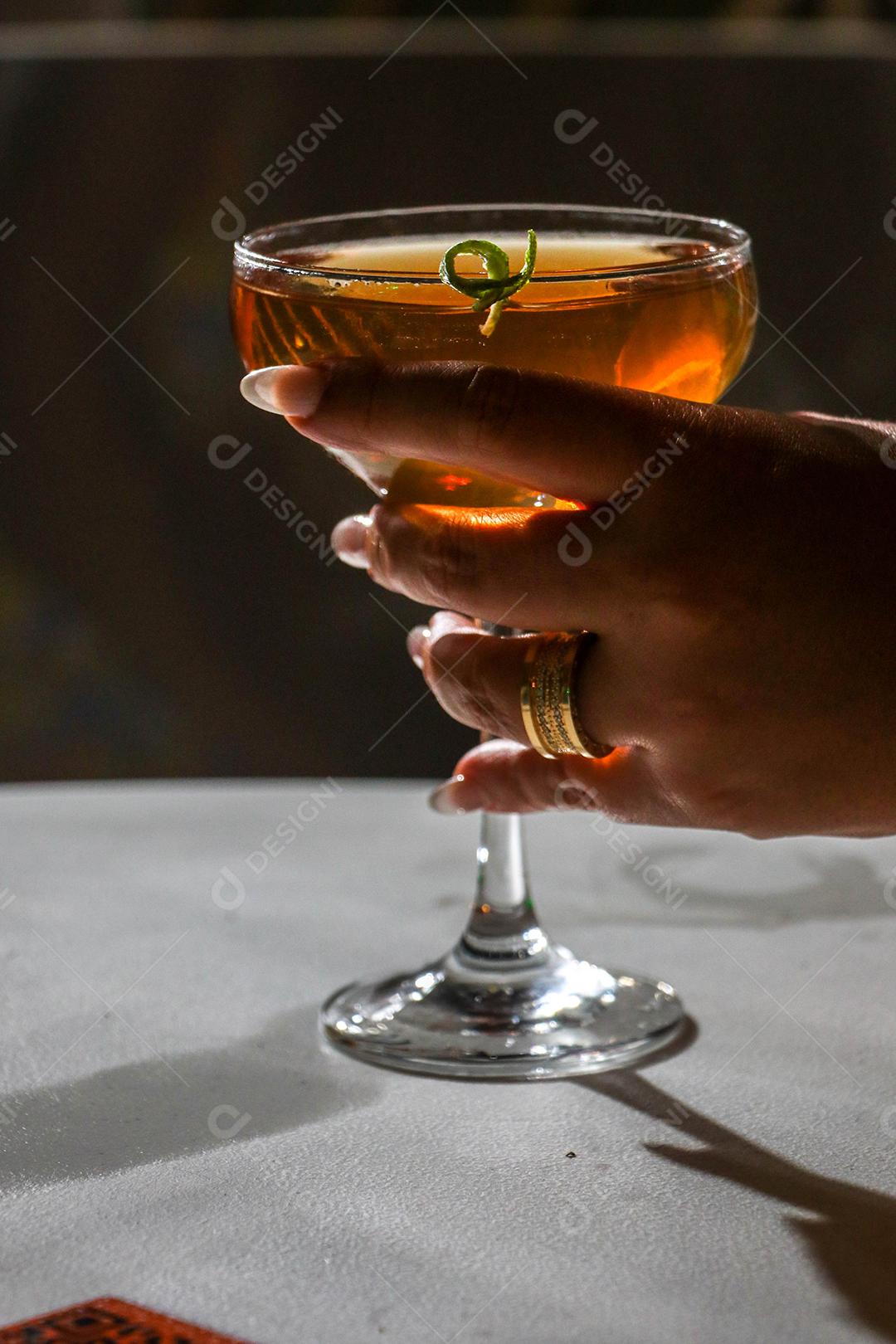 Mãos de pessoas segurando taça de vidro bebida suco fundo preto