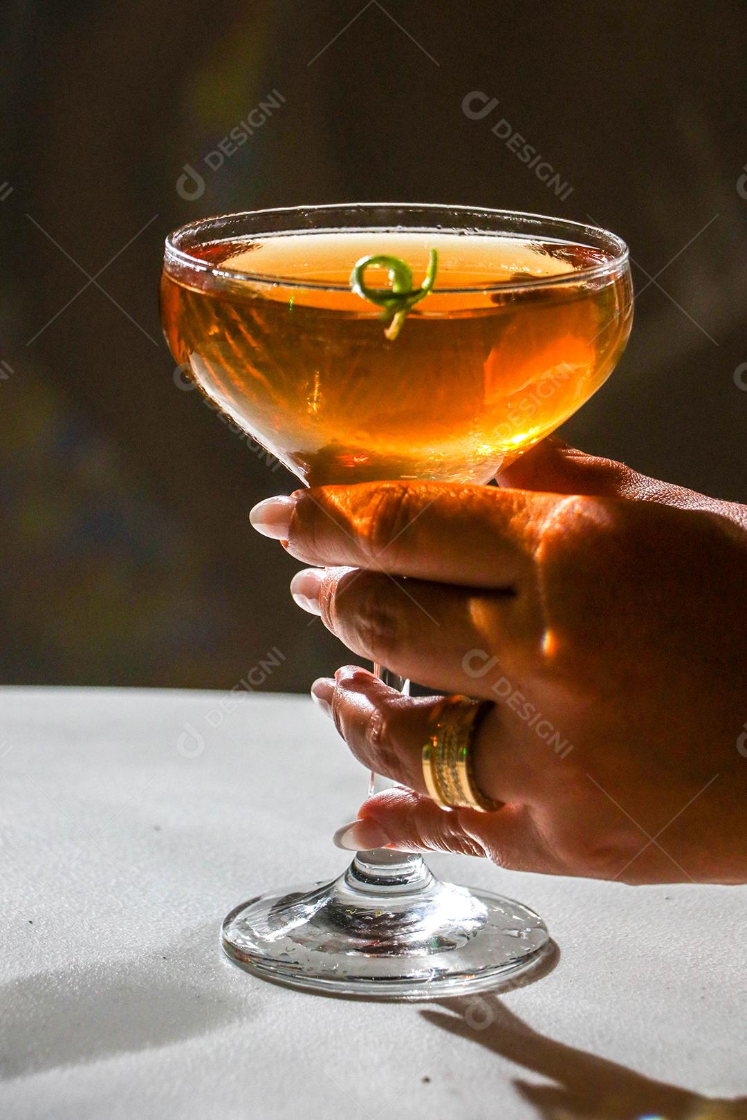 Mãos de pessoas segurando taça de vidro bebida suco fundo preto