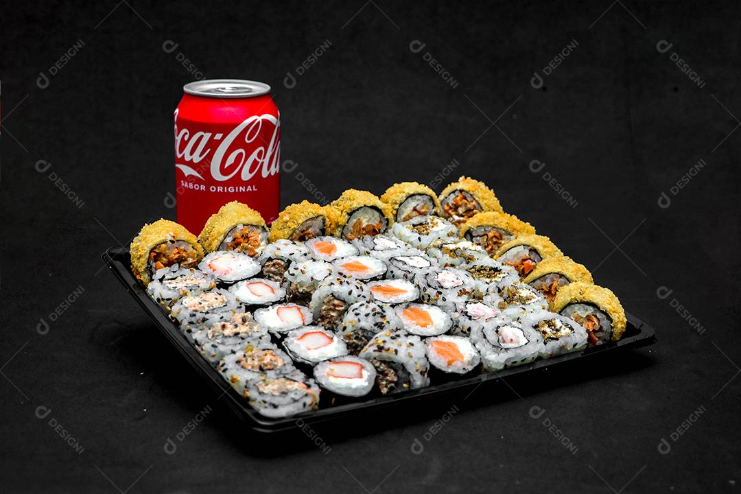Comida tipica japonesa sushi bebida coca cola sobre fundo preto