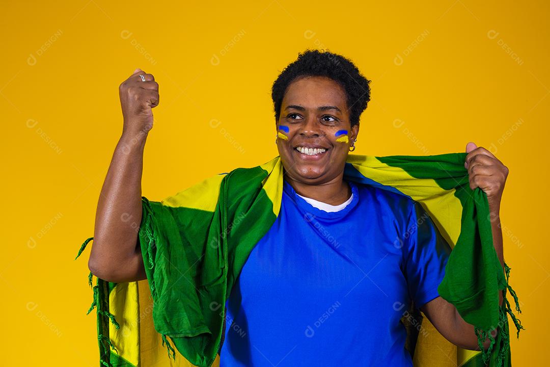 Torcedor feminino brasileiro maduro comemorando em fundo amarelo. sim