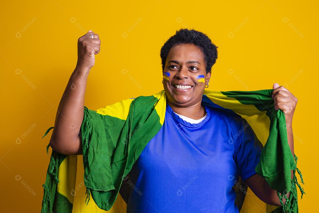 Torcedor feminino brasileiro maduro comemorando em fundo amarelo. sim