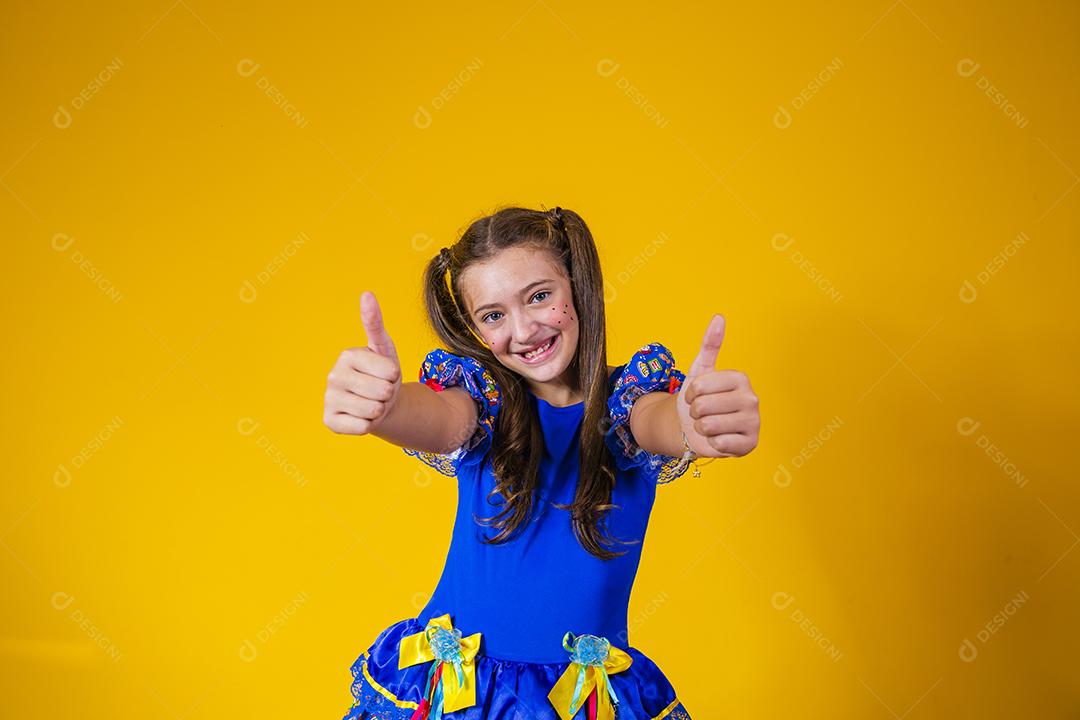garota caucasiana com roupa de festa junina com o polegar para cima.