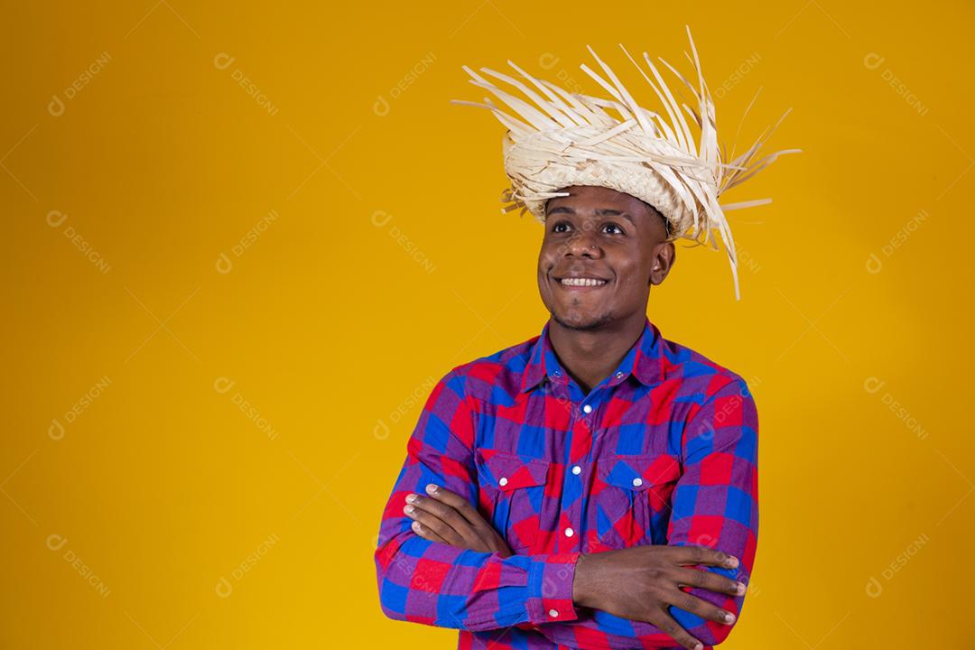 Homem afro brasileiro vestindo roupas típicas para Festa Junina com