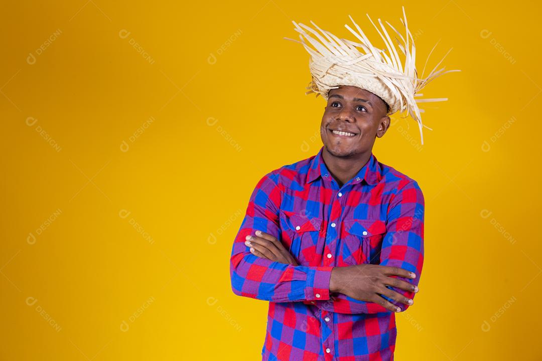 Homem afro brasileiro vestindo roupas típicas para Festa Junina com
