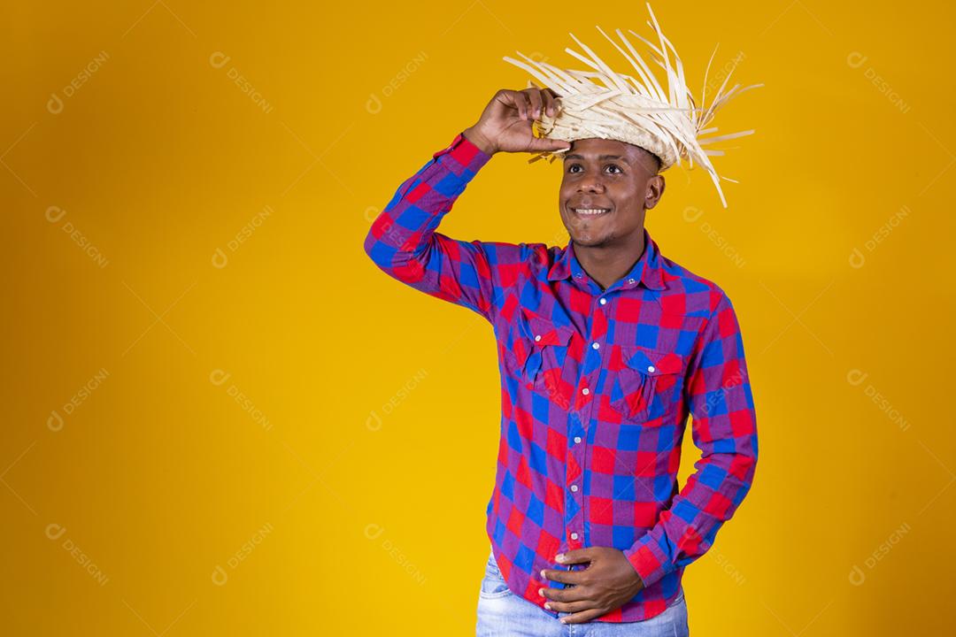 Homem afro brasileiro vestindo roupas típicas para a Festa Junina