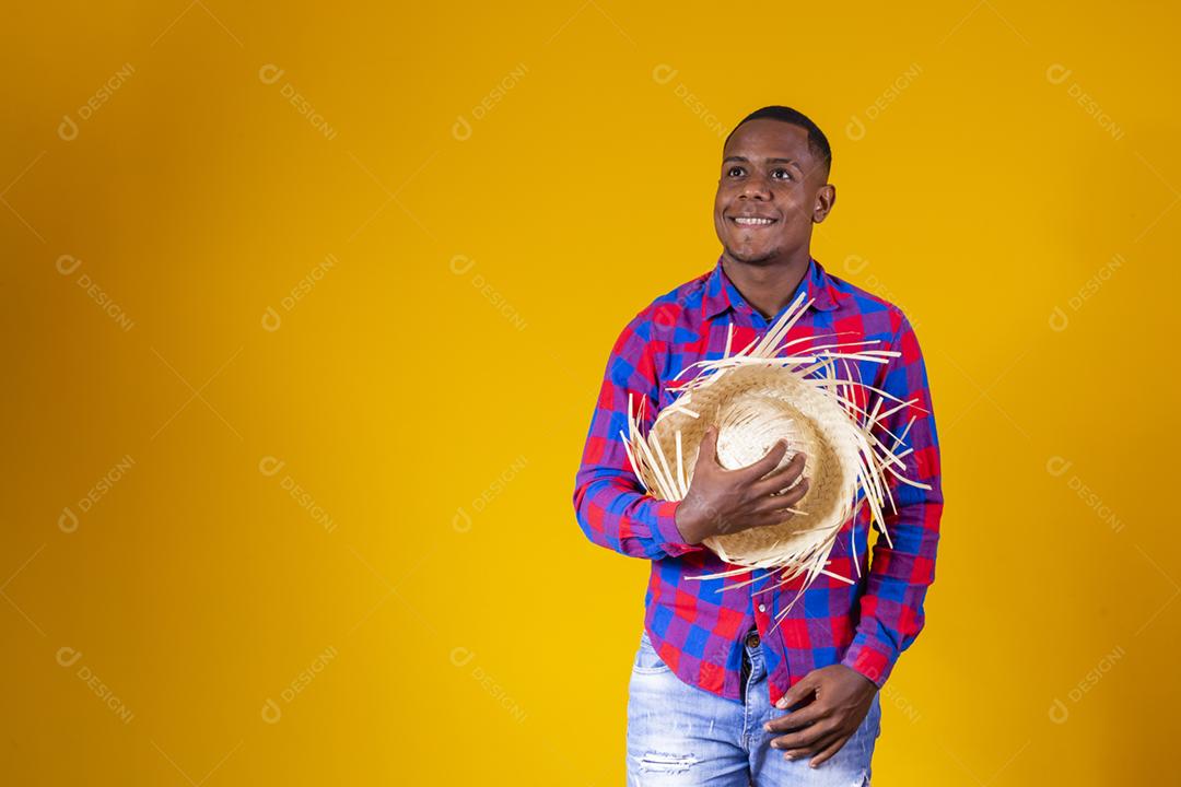 Homem afro brasileiro vestindo roupas típicas para a Festa Junina