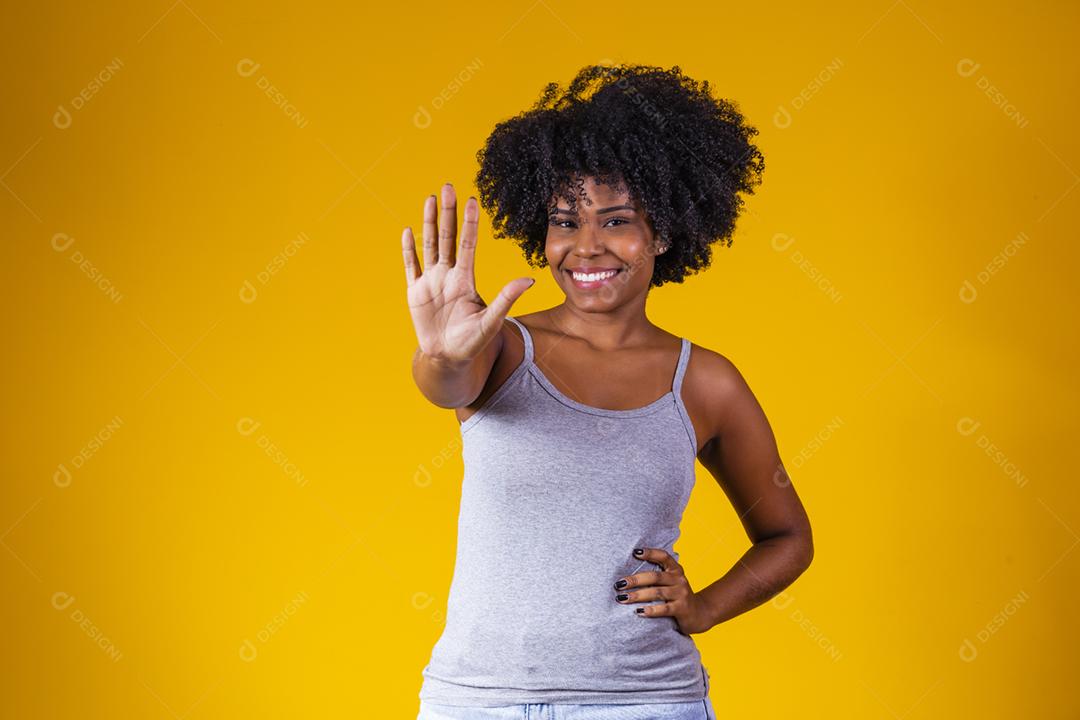 mulher afro com cabelo encaracolado mostrando a palma da mao
