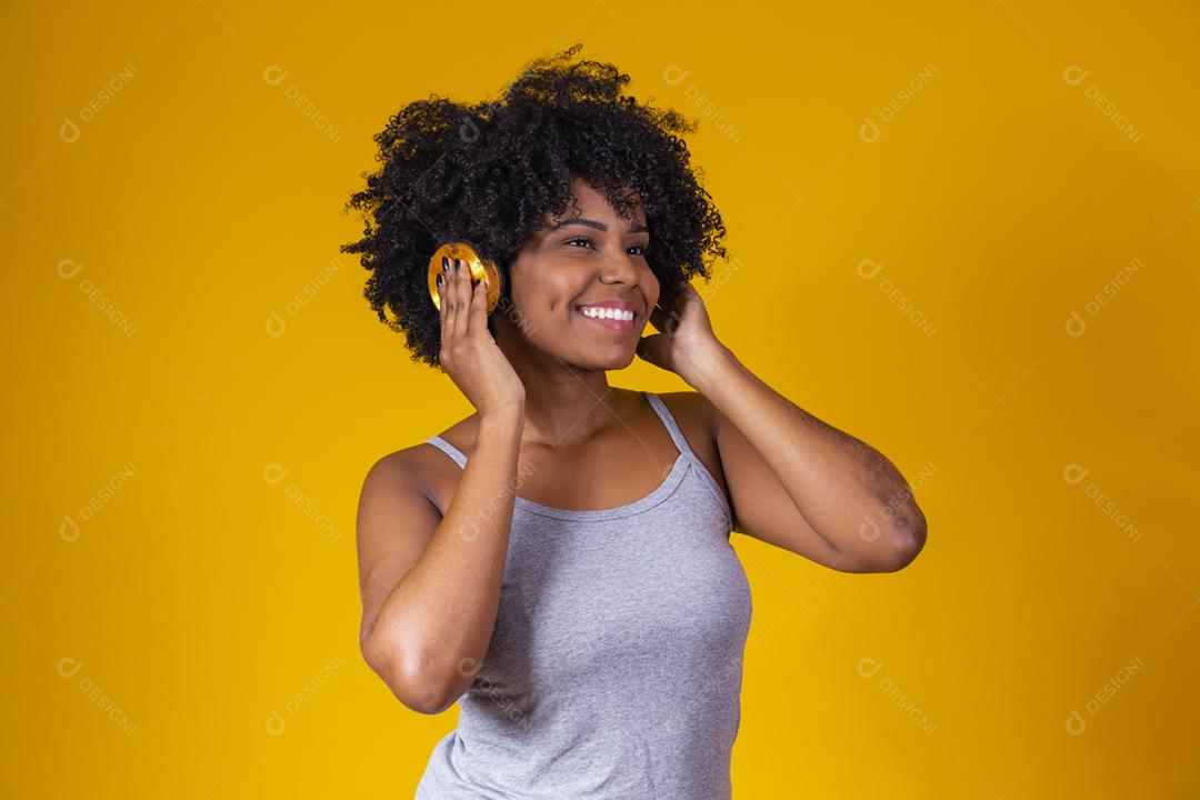 Mulher afro escutando musica com fones de ouvido