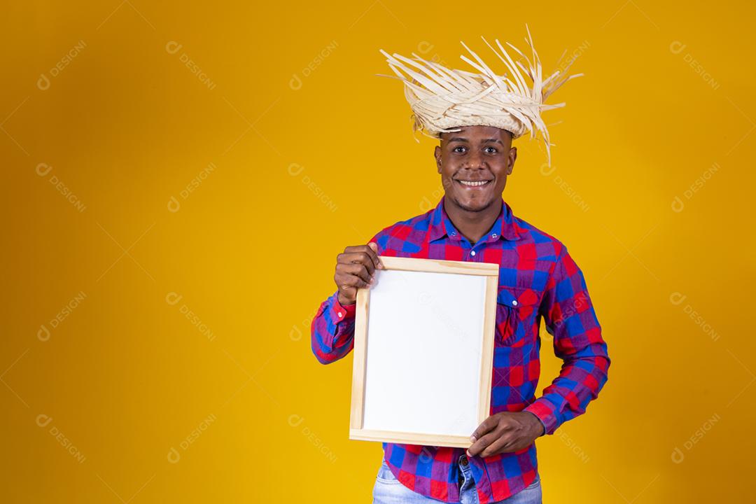 Homem afro brasileiro vestindo roupas típicas para a Festa Junina