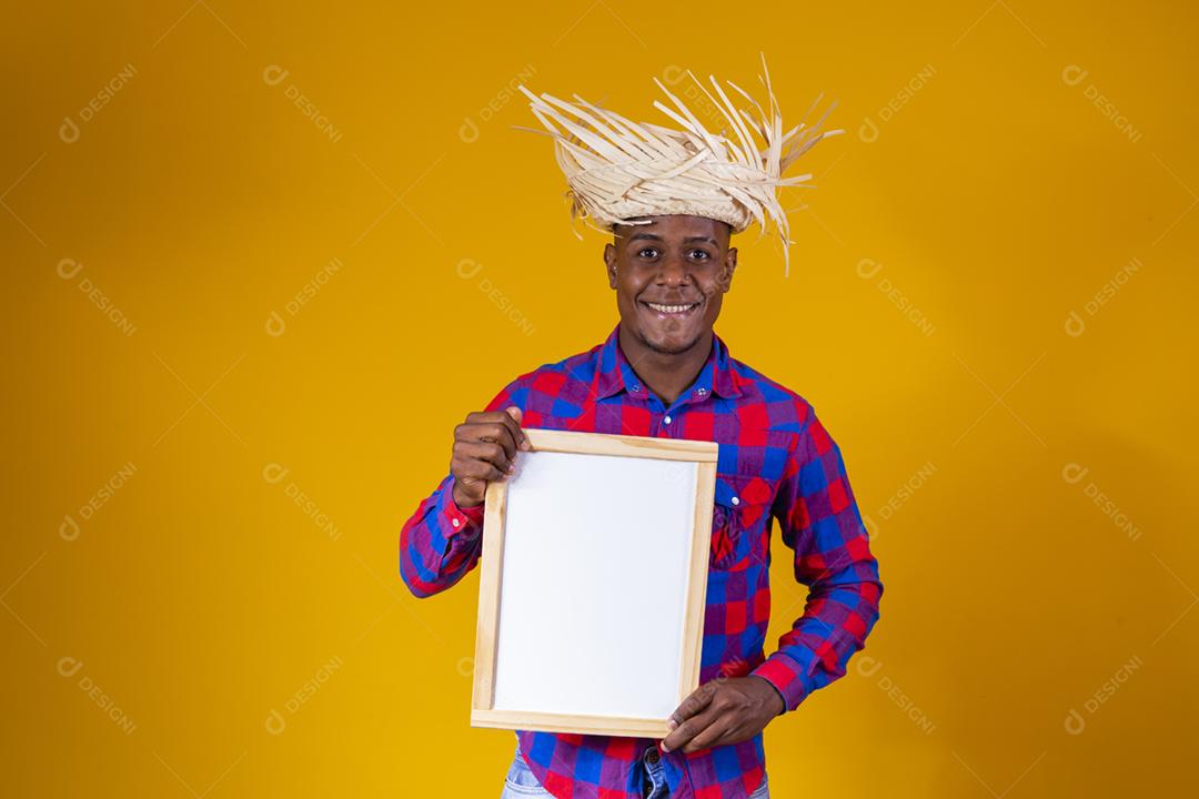 Homem afro brasileiro vestindo roupas típicas para a Festa Junina
