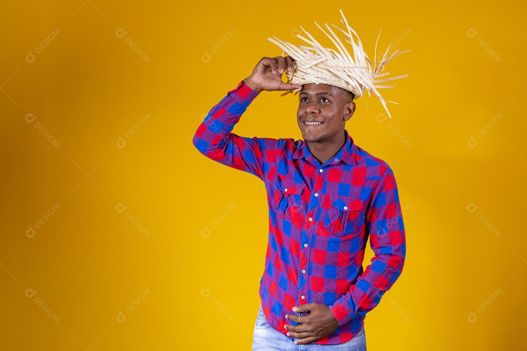 Homem afro brasileiro vestindo roupas típicas para a Festa Junina