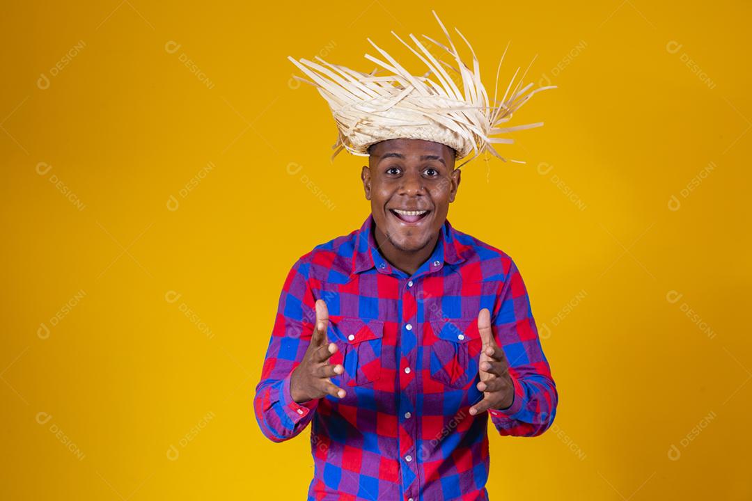 Homem afro brasileiro vestindo roupas típicas para a Festa Junina