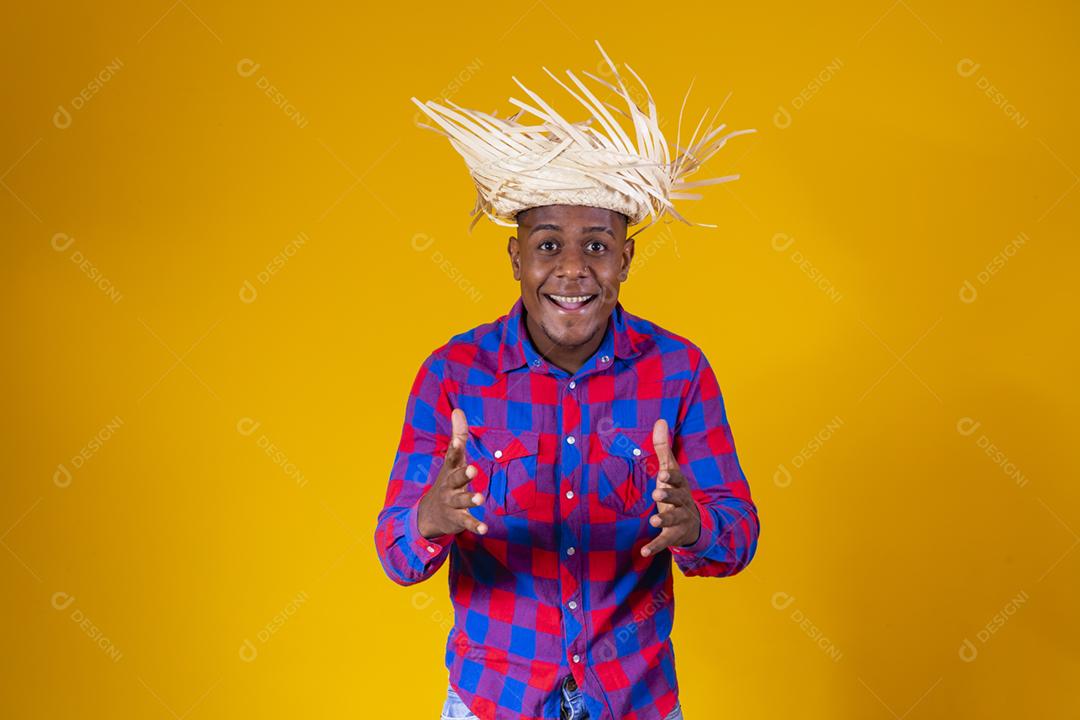 Homem afro brasileiro vestindo roupas típicas para a Festa Junina