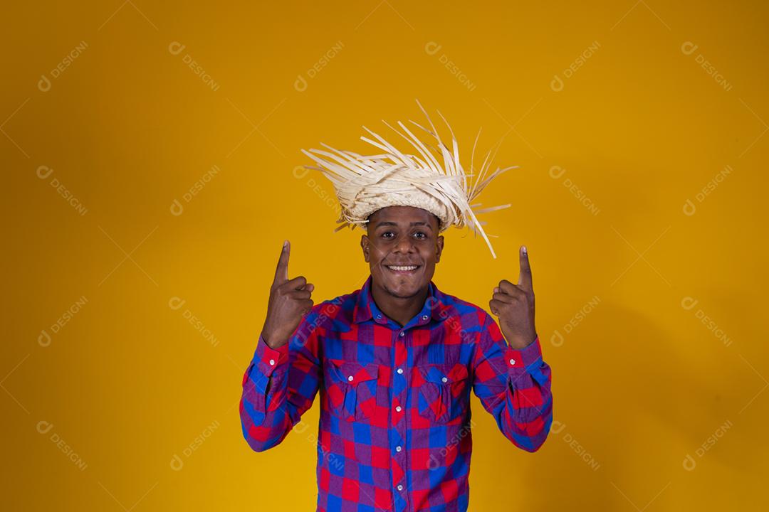 Homem afro brasileiro vestindo roupas típicas para a Festa Junina