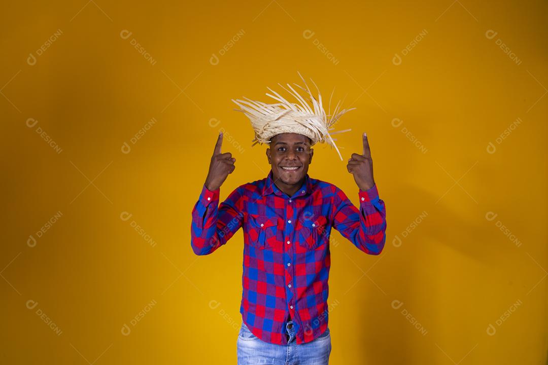 Homem afro brasileiro vestindo roupas típicas para a Festa Junina