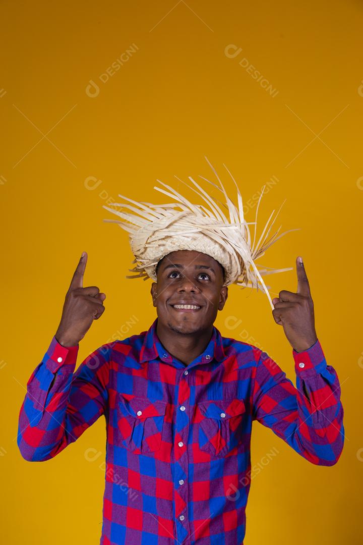 Homem afro brasileiro vestindo roupas típicas para a Festa Junina